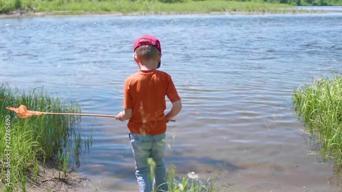 Boy fishing net on the river Bank. Beautiful summer landscape. Outdoor recreation. photo