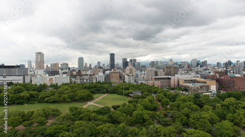 Aerial view of moat around castle park, Osaka business district and spectacular mountains surrounding the city from Osaka Castle. © Kenishirotie