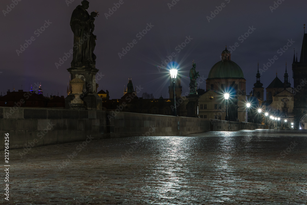 Karlsbrücke in Prag über die Moldau am Morgen. Nasses Kopfsteinpflaster.