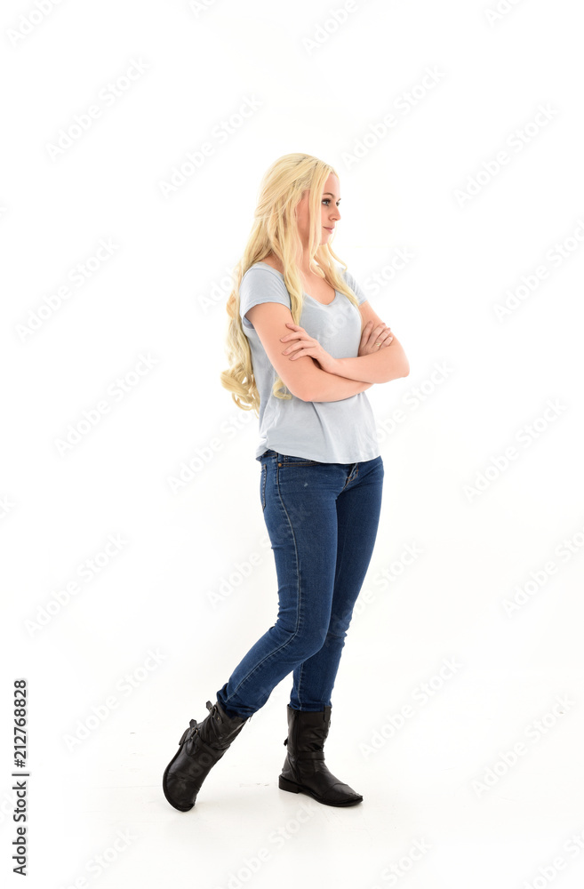 full length portrait of blonde girl wearing blue shirt and jeans, standing pose isolated on white studio background. full length portrait of blonde girl wearing blue shirt and jeans, standing pose isolated on white studio background.