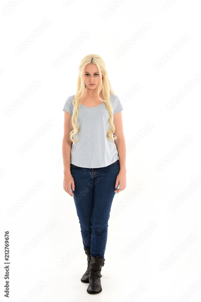 full length portrait of blonde girl wearing blue shirt and jeans, standing pose isolated on white studio background. full length portrait of blonde girl wearing blue shirt and jeans, standing pose isolated on white studio background.