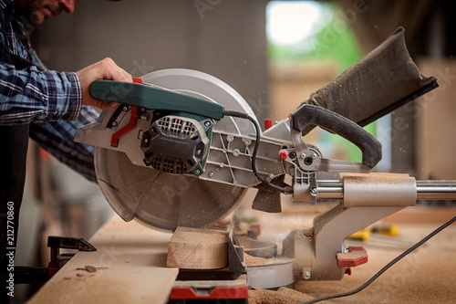 Canvas Print Carpenter work with circular saw for cutting boards, the man sawed bars, constru