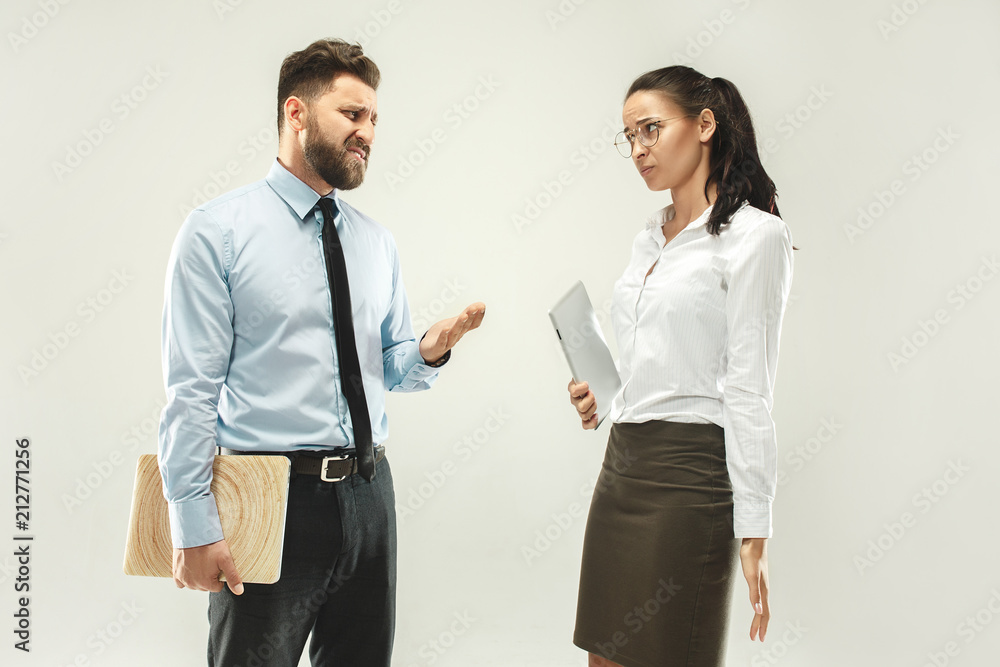 Angry boss. Man and his secretary standing at office or studio Angry boss. Man and his secretary standing at office or studio