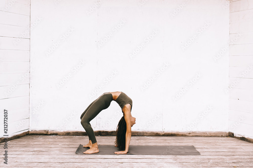 Attractive model in yoga pose on white background in sexual clothes