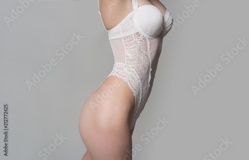 Lingerie. Body of young female on grey background in studio. Advertising concept of women's undearwear for special occasions. Female health, intim hygiene. Lady wearing sensual lingerie. Sexy woman.
