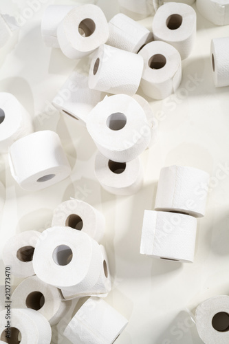 viele Toilettenpapier-Rollen vor weissem Hintergrund photo