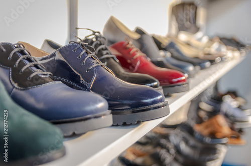 Row of shoes on shelves with blurred background. Selective focus