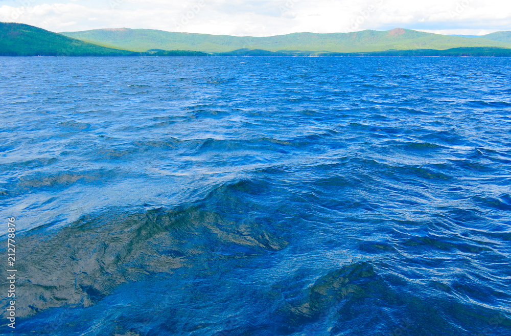 Sea surface with slight rippling water with a mountain landscape in the background