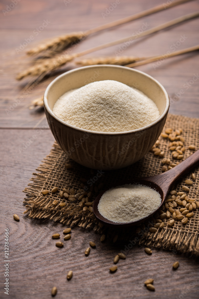 Raw unprepared semolina flour also known as Rava powder in Hindi in bowl or spoon. close-up isolated on white or moody background. selective focus Raw unprepared semolina flour also known as Rava powder in Hindi in bowl or spoon. close-up isolated on white or moody background. selective focus