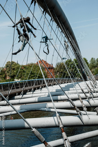 Bridge in Krakow via Vistula. Sculptures on the bridge. Statues on ropes. An interesting place was Krakow