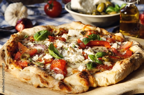 Herzhafte hausgemachte Pizza mit Feta Käse, Tomaten, Oliven und Basilikum