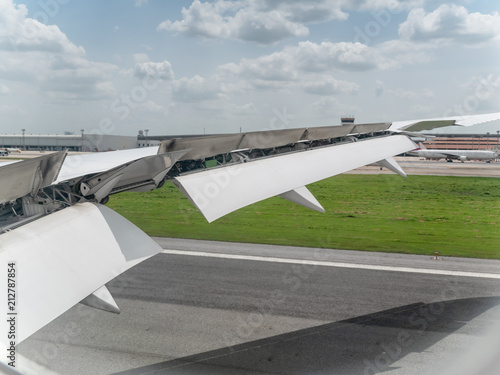 Schilderij op canvas Landing aircraft at the airport, Braking of the aircraft on the runway, wing of the plane is in working order