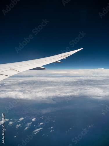 View from airplane window with blue sky and white clouds, background for travel holiday trip, Aircraft on the sky. © Jirapas