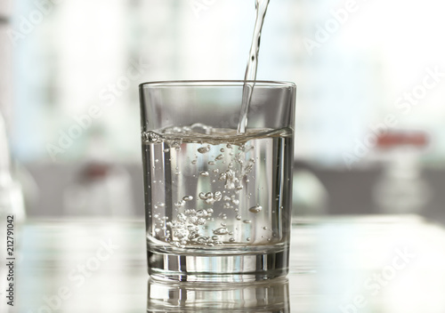 Pure water is poured into a glass.