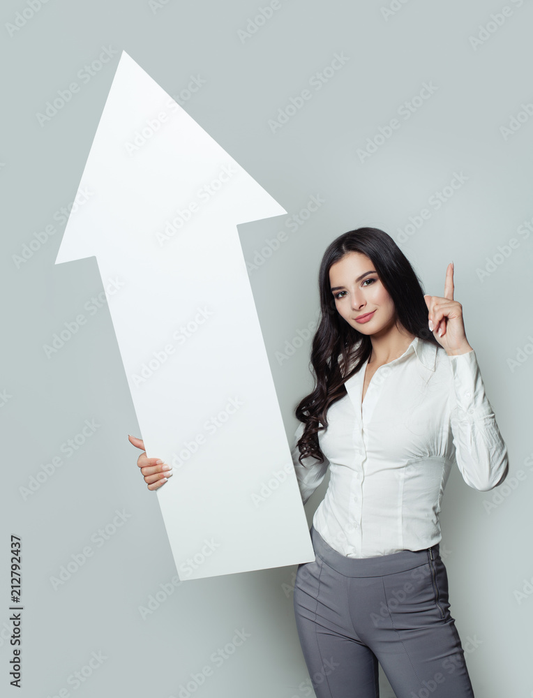 Successful Investment, Business Success and Shares Up Concept. Business Woman Pointing Up and Holding White Rising Arrow, Representing Business Growth. Successful Investment, Business Success and Shares Up Concept. Business Woman Pointing Up and Holding White Rising Arrow, Representing Business Growth.