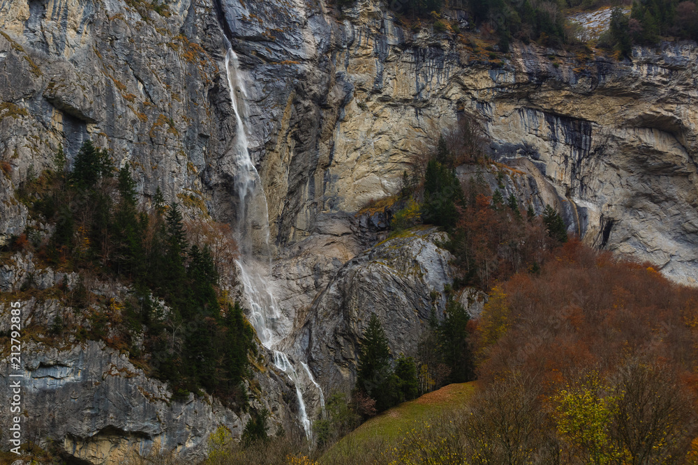 Fototapeta premium Beautiful autumn time at village of Lauterbrunnen in Swiss alps, gateway to famous Jungfrau. Set in a valley featuring rocky cliffs and the roaring