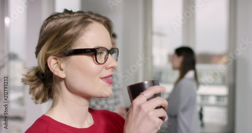 Confident brown hair woman with glasses drinking cup while listining to somebody photo