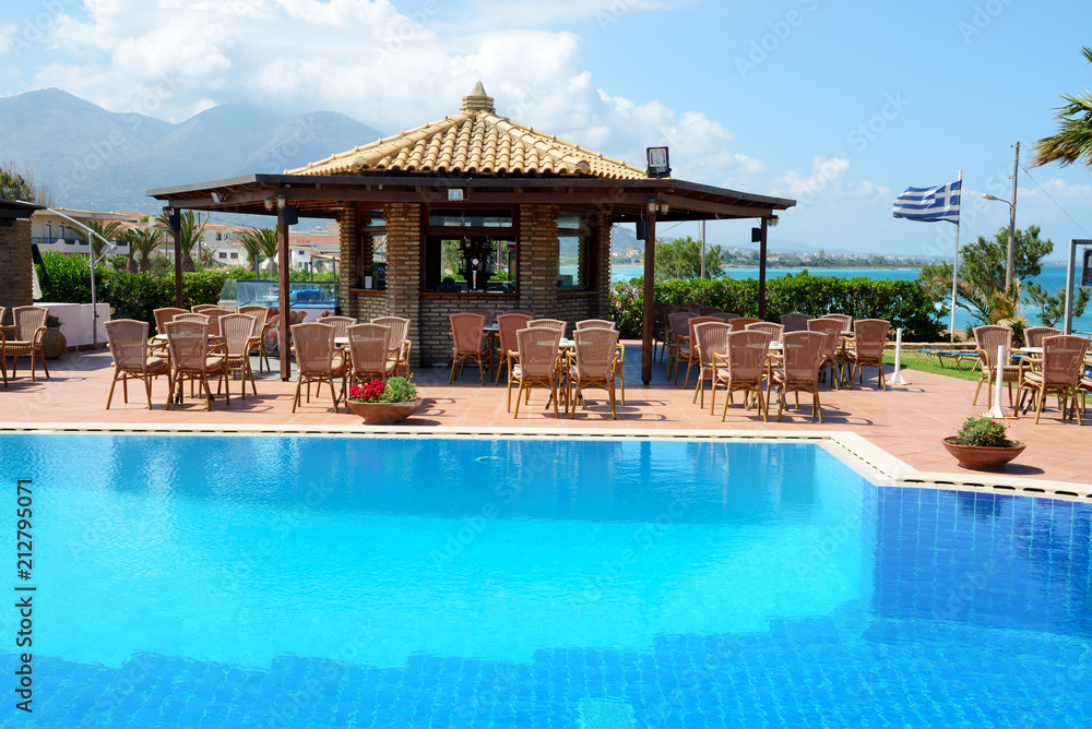 The swimming pool near bar and Greek flag, Peloponnes, Greece