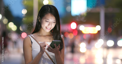 Photography Woman works on mobile phone in city at night
