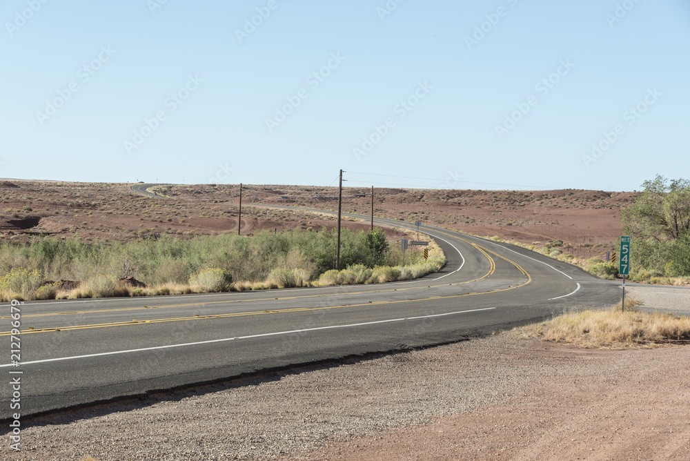 Solitary desert highway. Old asphalt road in a hot location