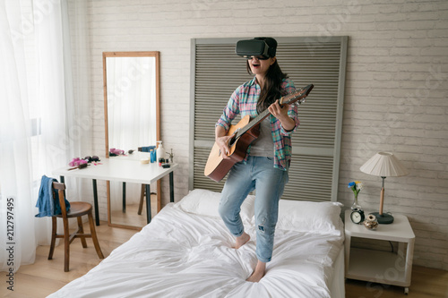 female musician playing VR on her bed