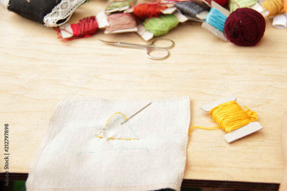 Sewing set: fabrics and threads on wooden table Sewing set: fabrics and threads on wooden table