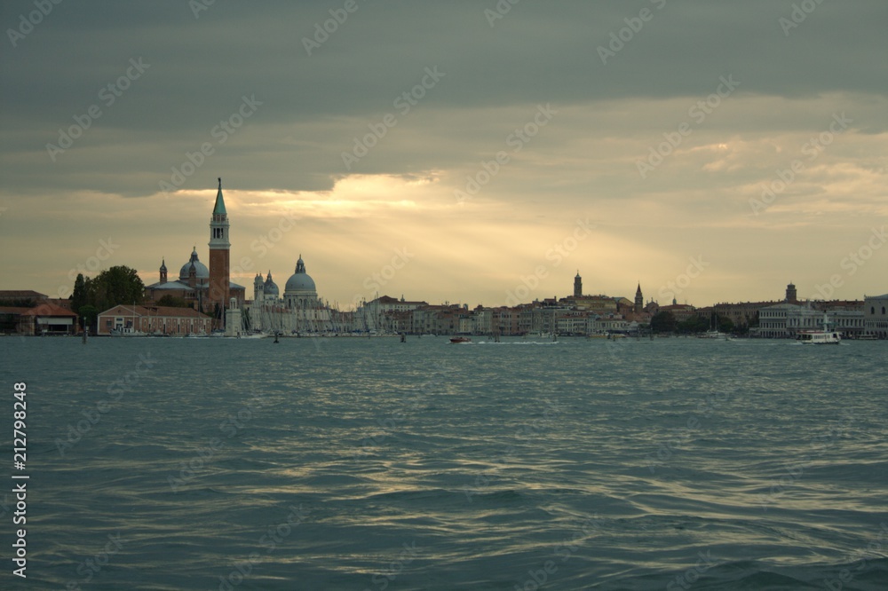 Sonnenstrahlen brechen durch den bedeckten Himmel über Venedig