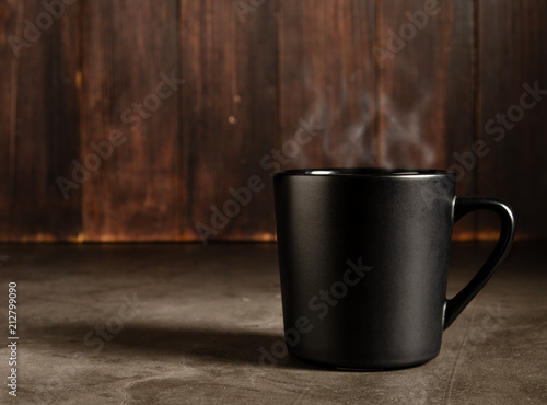 coffee in a black mug with dark wood background