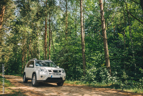 white suv in forest. car travel concept. lifestyle photo
