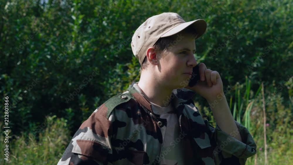 Young soldier relaxed talking on the phone. Sunny day Young soldier relaxed talking on the phone. Sunny day