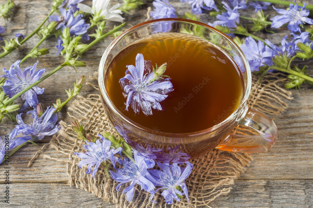 Chicory drink in Cup and flowers on rustic wooden background. Medicinal plant Cichorii. Chicory drink in Cup and flowers on rustic wooden background. Medicinal plant Cichorii.