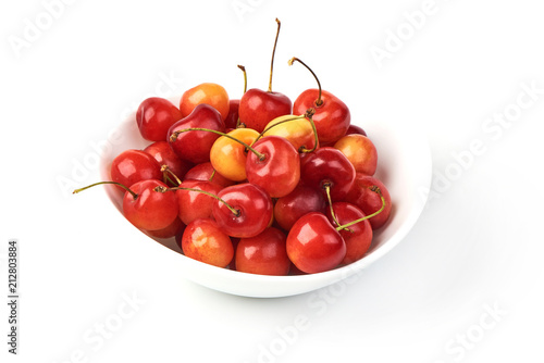 Sweet yellow cherry in white pot, isolated on white background. Close-up. photo