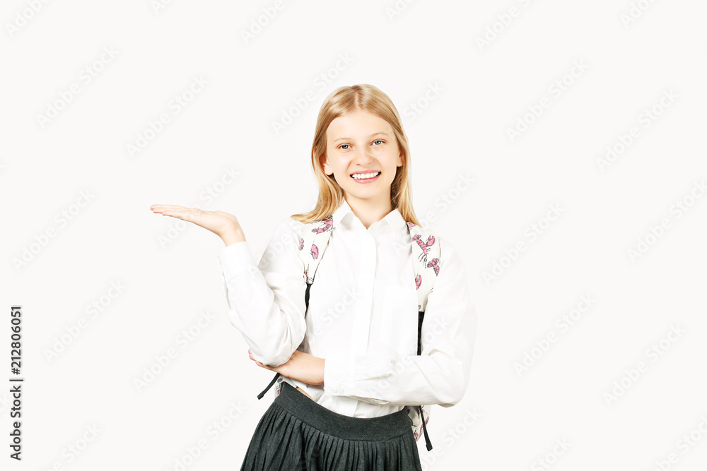 Close up portrait, young beautiful happy teenage school girl, standing on white background, pretending to hold empty copy space, smiling wide, perfect teeth. Back to school sale concept. Isolated. Close up portrait, young beautiful happy teenage school girl, standing on white background, pretending to hold empty copy space, smiling wide, perfect teeth. Back to school sale concept. Isolated.