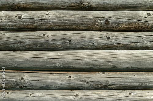 old wall of wooden round logs of gray color