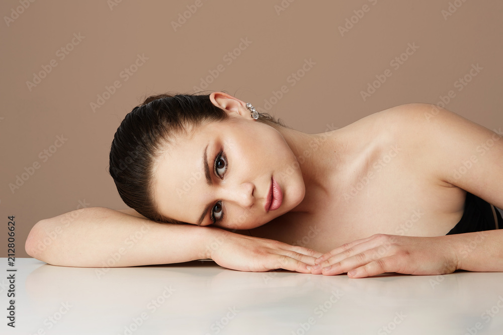 Beautiful woman with big brown eyes and dark eyebrows relaxing over empty color studio background.Model with light nude make-up.Copy paste space,close up.Healthcare skin makeup concept Beautiful woman with big brown eyes and dark eyebrows relaxing over empty color studio background.Model with light nude make-up.Copy paste space,close up.Healthcare skin makeup concept