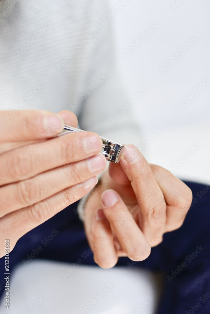young man cutting his fingernails