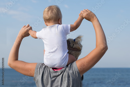 Obraz na plátně Little blonde boy sits on shoulders of his mother and watches the sea