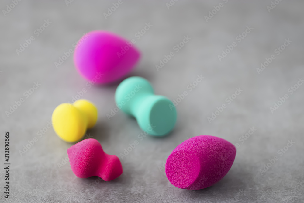 Multicolored cosmetic sponges on a gray concrete background. Multicolored cosmetic sponges on a gray concrete background.