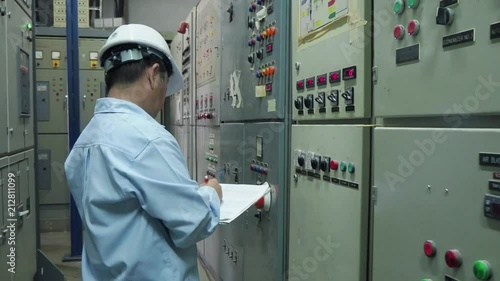 An elder engineer checking on computer server  in an industrial factory in 4k