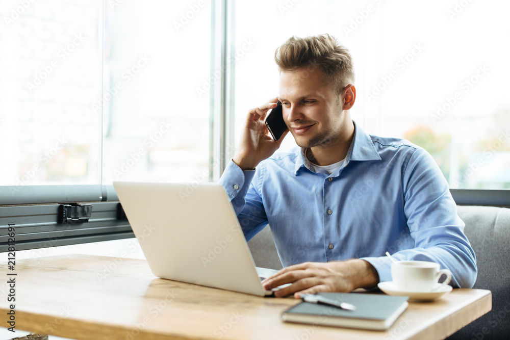 Stylish young man calling by the phone to solve business problems. Online consultation by phone. Freelancer discussing the development and planning of his online project. Outsourcing. Mobile services. Stylish young man calling by the phone to solve business problems. Online consultation by phone. Freelancer discussing the development and planning of his online project. Outsourcing. Mobile services.