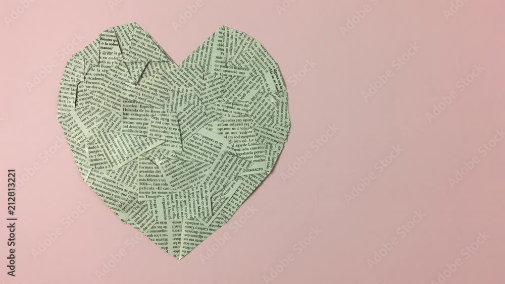 Corazon hecho de papel de periodicos con la frase debajo “I love reading”
