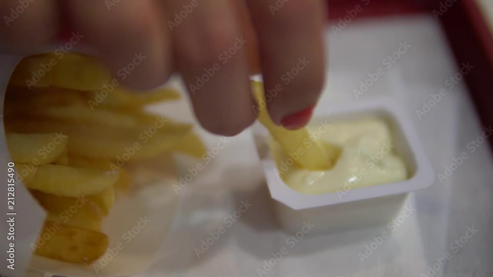 Female hand takes french fries. Close up of female hands with french fries. Female hand takes french fries. Close up of female hands with french fries.
