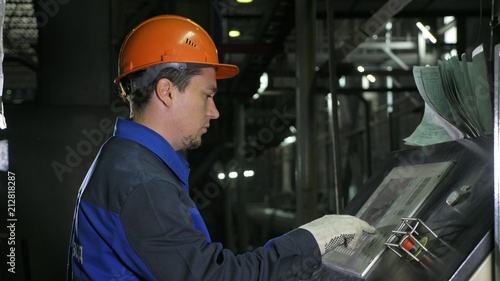 Operator monitors control panel of production line. Manufacture of plastic water pipes of the factory. Process of making plastic tubes on machine tool with the use of water and air pressure.