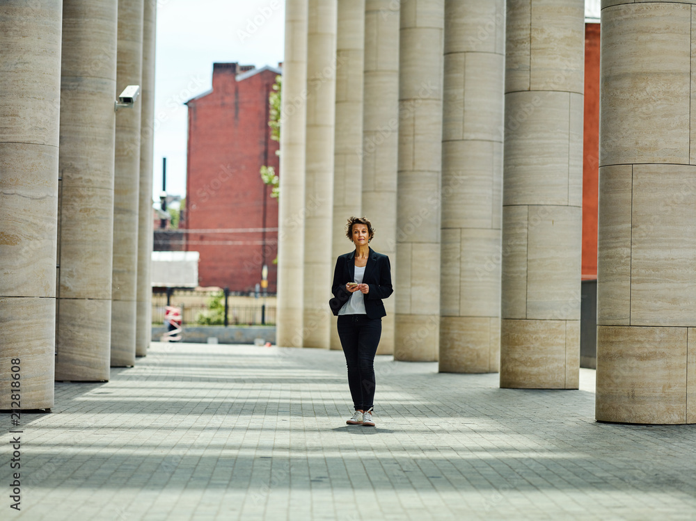 Adult formal woman in black suit in passage Adult formal woman in black suit in passage
