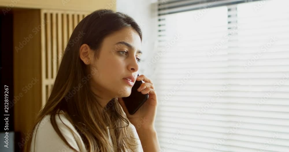 Woman talking on mobile phone in living room 4k Woman talking on mobile phone in living room 4k