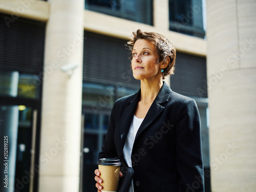 Adult businesswoman with coffee outside