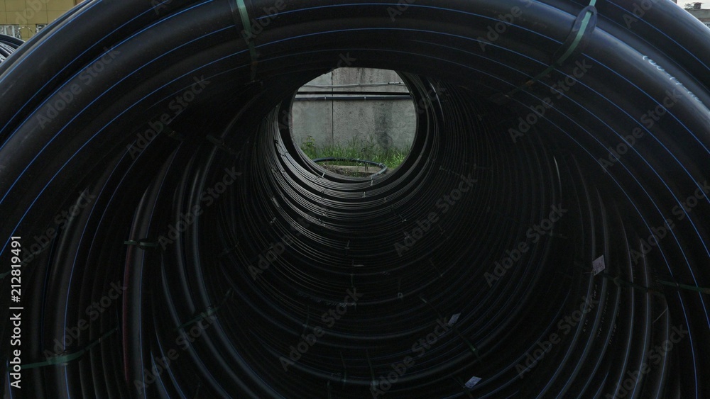 Obraz premium Warehouse of finished plastic pipes industrial outdoors storage site. Manufacture of plastic water pipes factory. Process of making plastic tubes on the machine tool with the use of water and air
