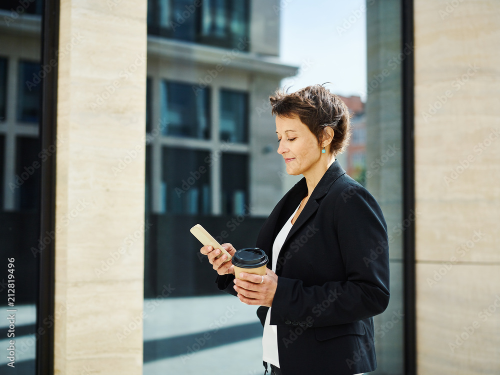 Smart businesswoman using phone and having coffee Smart businesswoman using phone and having coffee