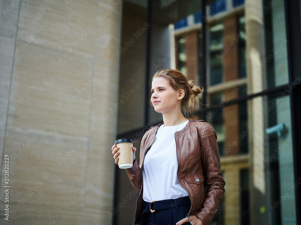 Young woman in stylish outfit holding coffee