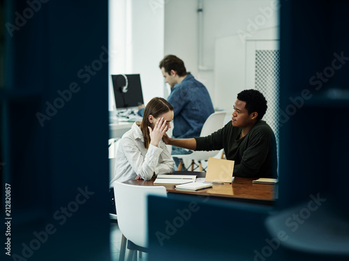 Multiracial students sitting in library